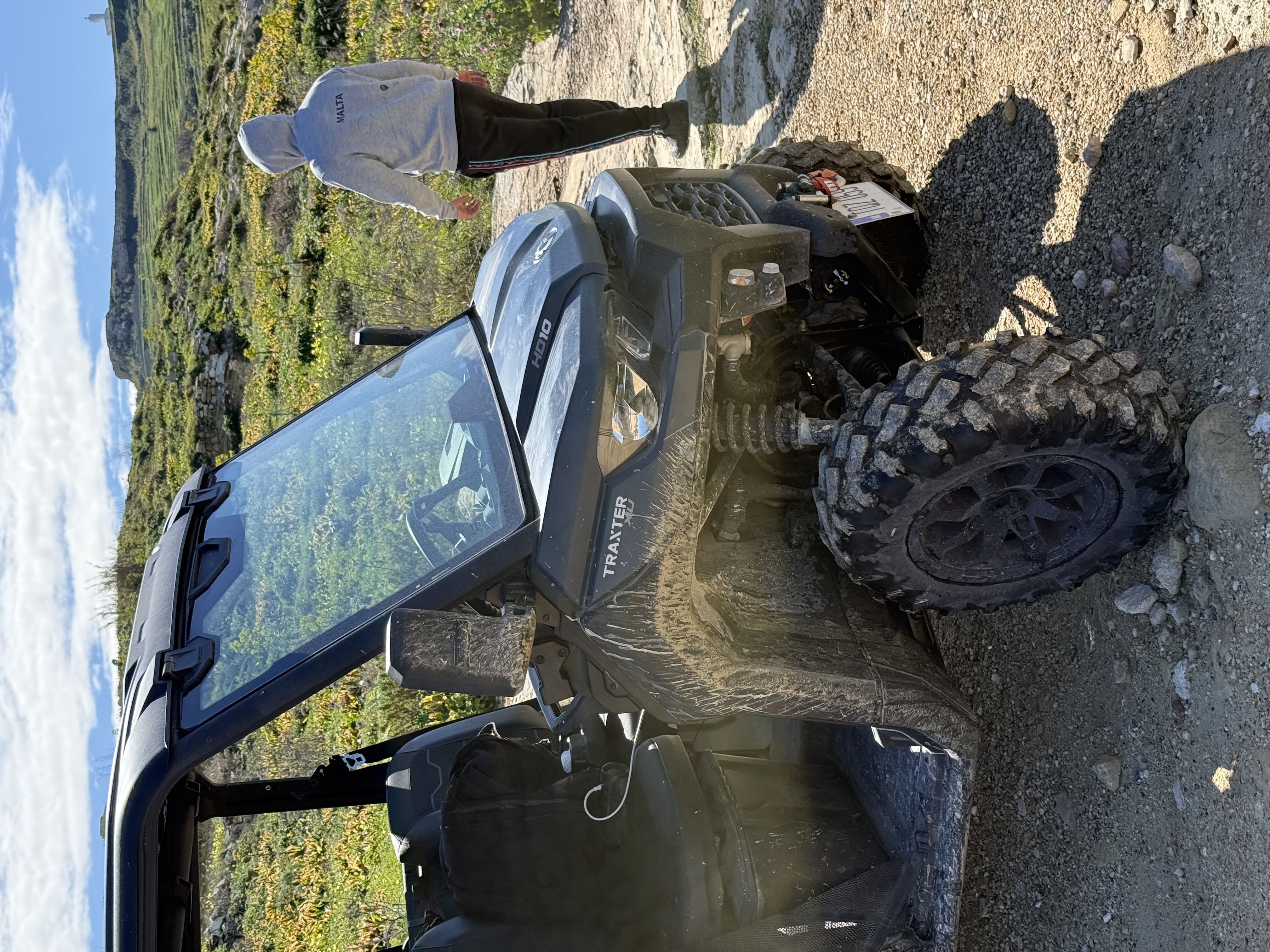 Can-Am Traxter front view on a muddy Gozitan trail with green hills behind