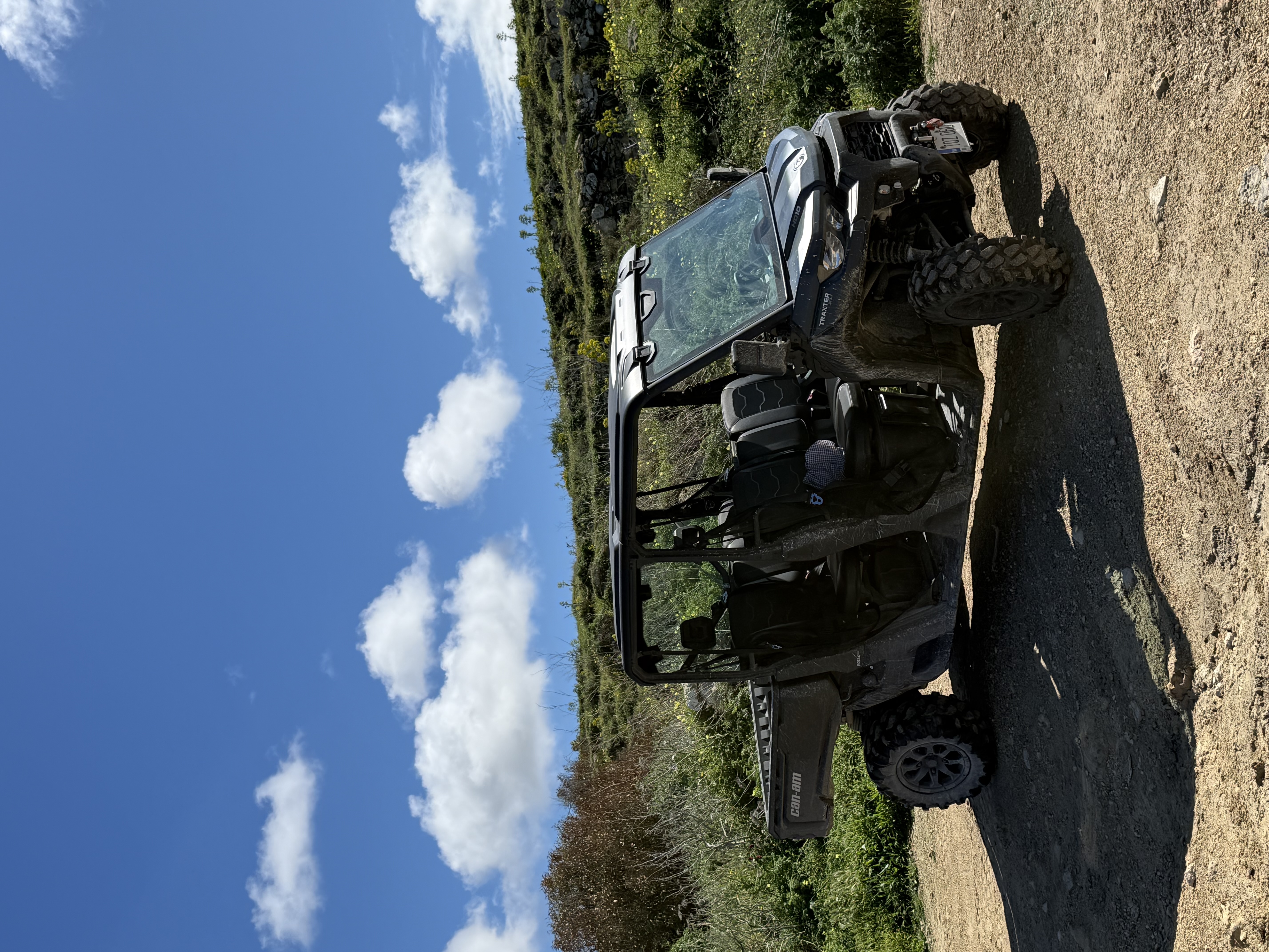 Can-Am Traxter HD10 full side view on a rocky Gozo hillside under blue sky