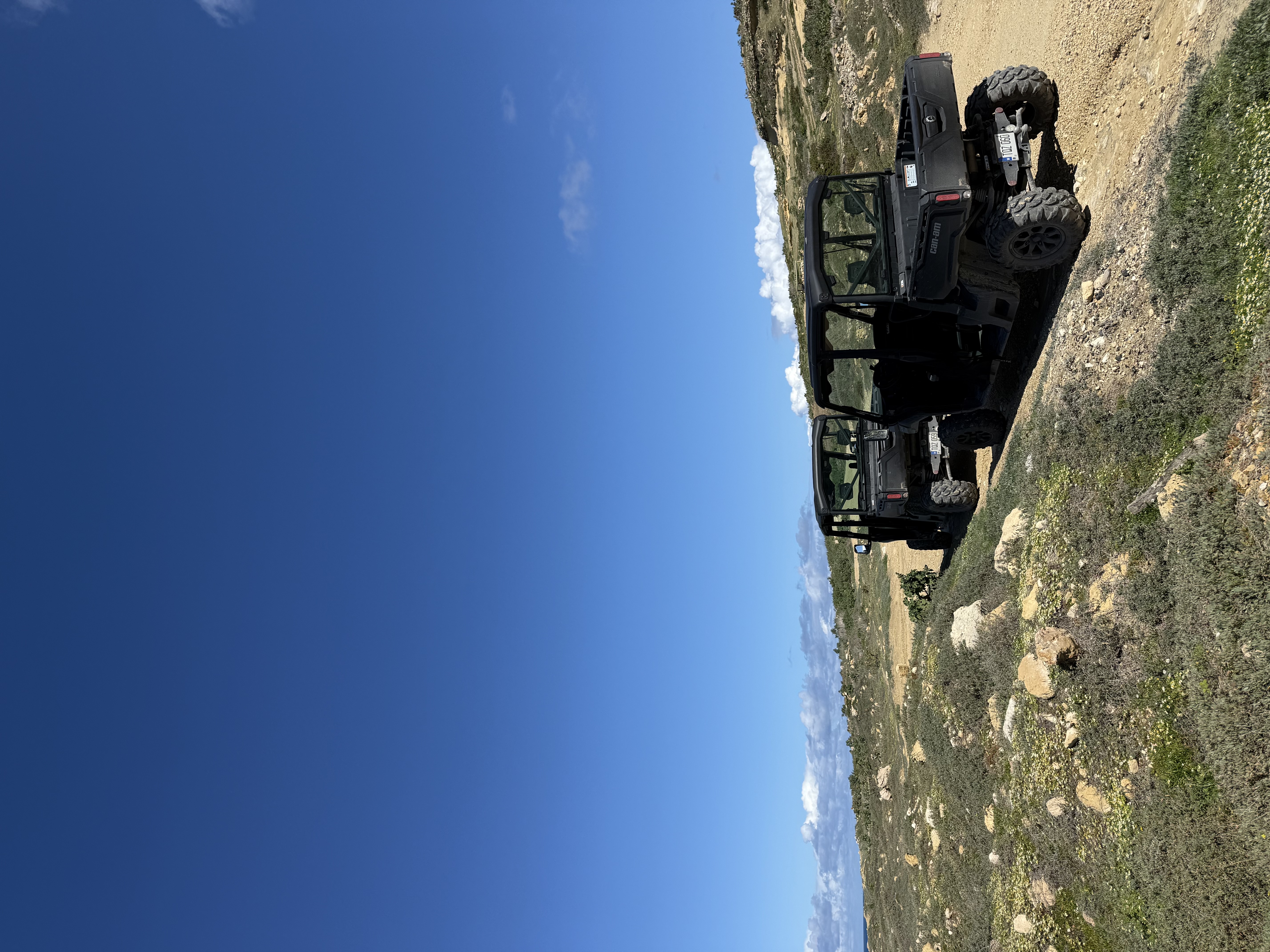 Two Can-Am Traxter jeeps on a rocky Gozo trail under a vivid blue sky